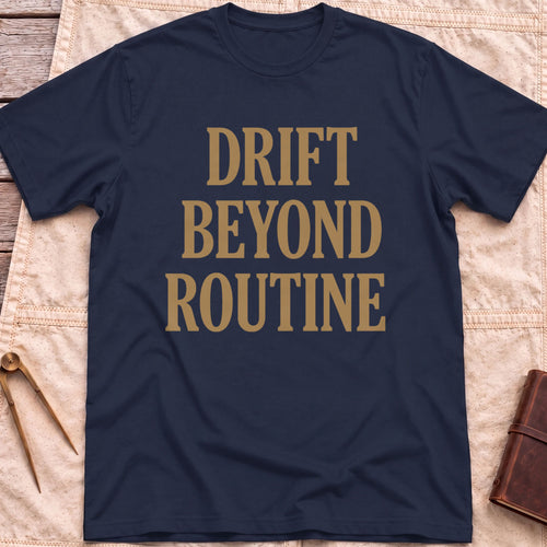 Front view of the navy Drift Beyond Routine T-Shirt with the words Drift Beyond Routine in large tan capitals.
