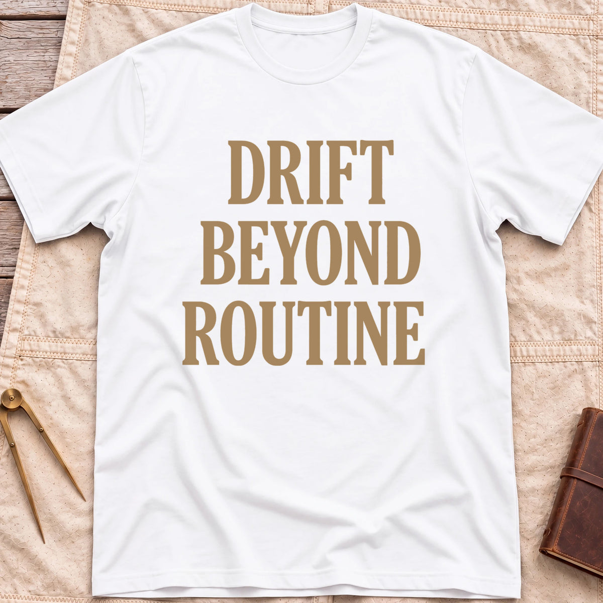 Front view of the white Drift Beyond Routine T-Shirt with the words Drift Beyond Routine in large tan capitals.