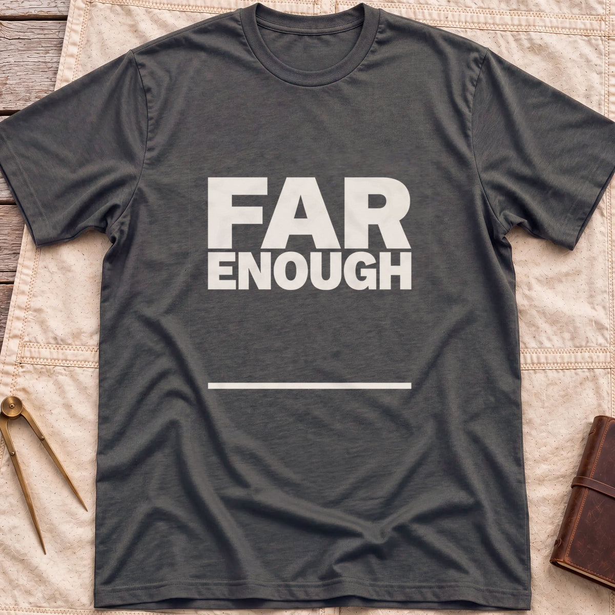 Front view of the dark heather Far Enough T-Shirt with the words Far Enough in bold block capitals above a single line.