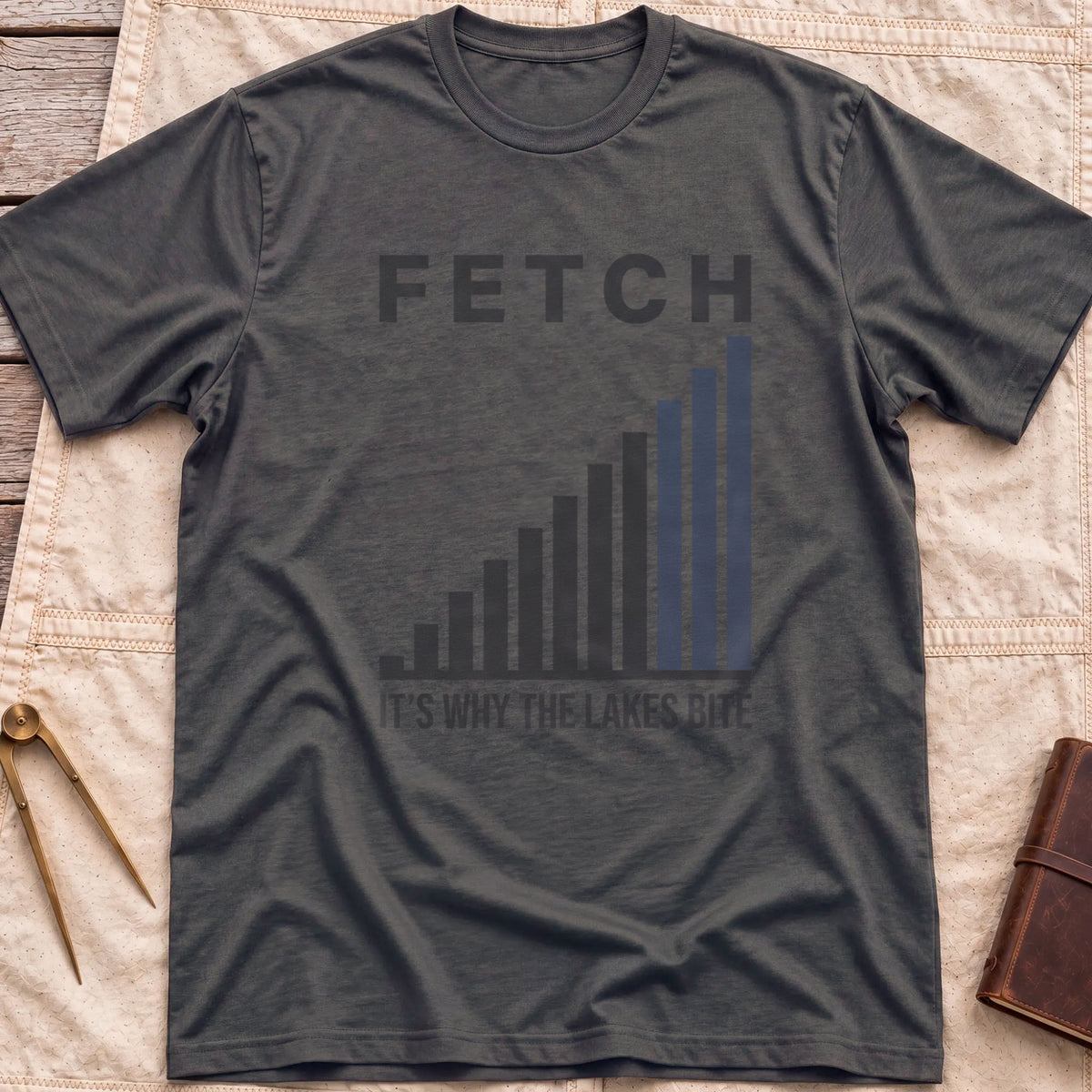 Front view of the dark heather Fetch T-Shirt with a rising bar chart and the words It's Why the Lakes Bite.