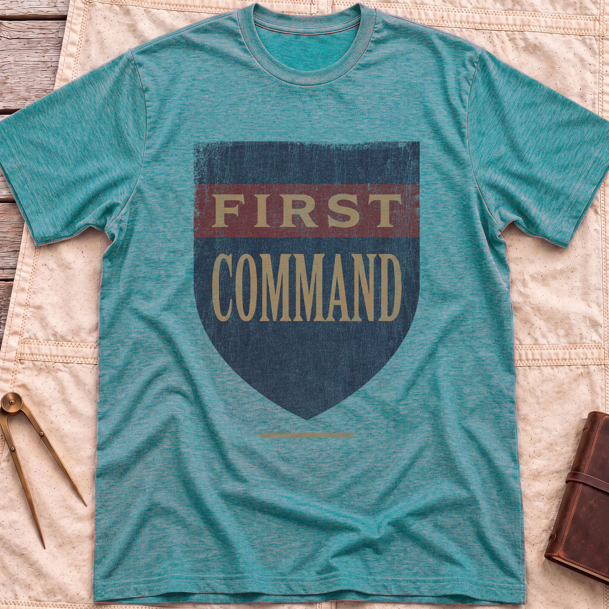 Front view of the heather galapagos blue First Command T-Shirt with a distressed navy shield and a red band, lettered First Command.