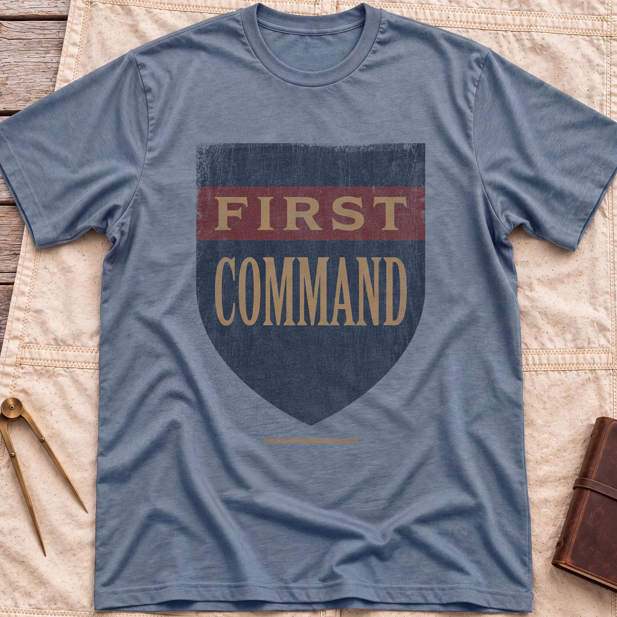 Front view of the heather indigo First Command T-Shirt with a distressed navy shield and a red band, lettered First Command.