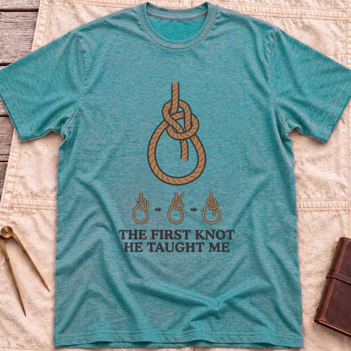 Front view of the heather galapagos blue First Knot He Taught Me T-Shirt with a large rope knot above three small diagrams showing it being tied.