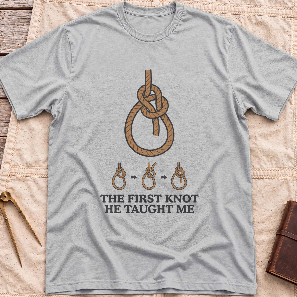 Front view of the sport grey First Knot He Taught Me T-Shirt with a large rope knot above three small diagrams showing it being tied.
