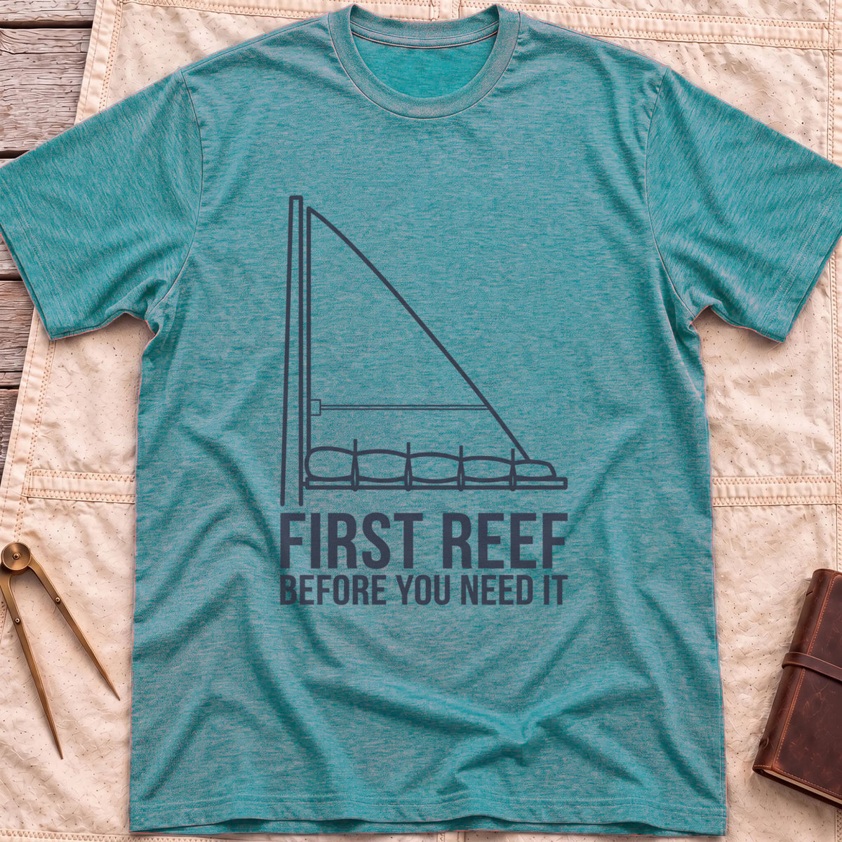 Front view of the heather galapagos blue First Reef T-Shirt with a line drawing of a sail with its lower section folded along the boom, above the words Before You Need It.