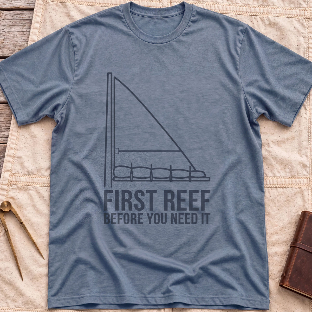 Front view of the heather indigo First Reef T-Shirt with a line drawing of a sail with its lower section folded along the boom, above the words Before You Need It.