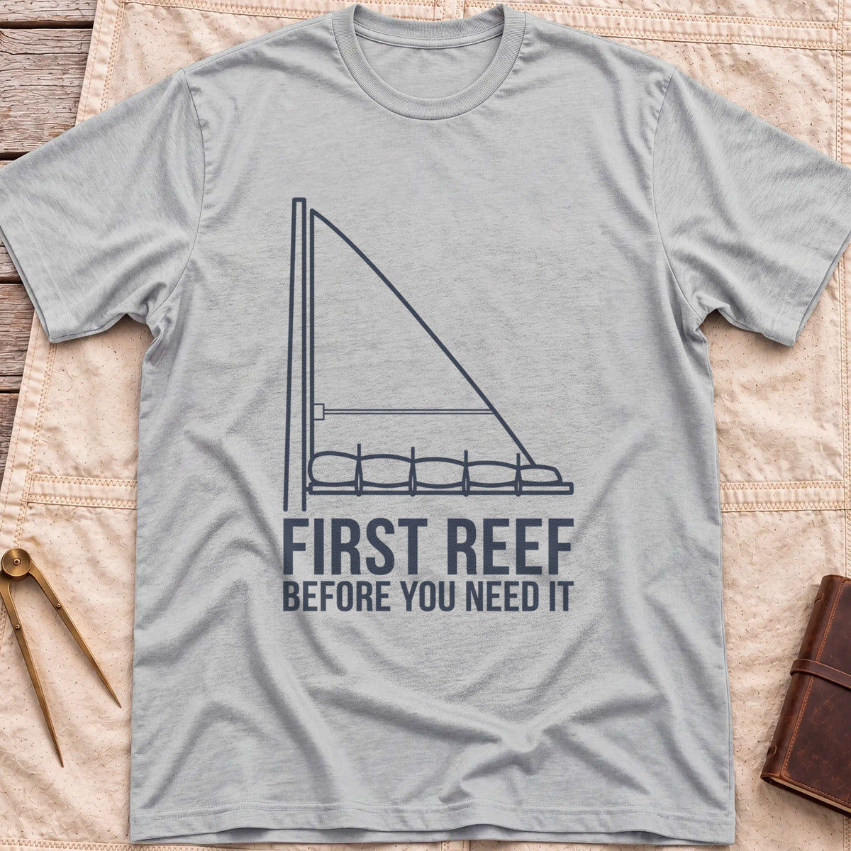 Front view of the sport grey First Reef T-Shirt with a line drawing of a sail with its lower section folded along the boom, above the words Before You Need It.