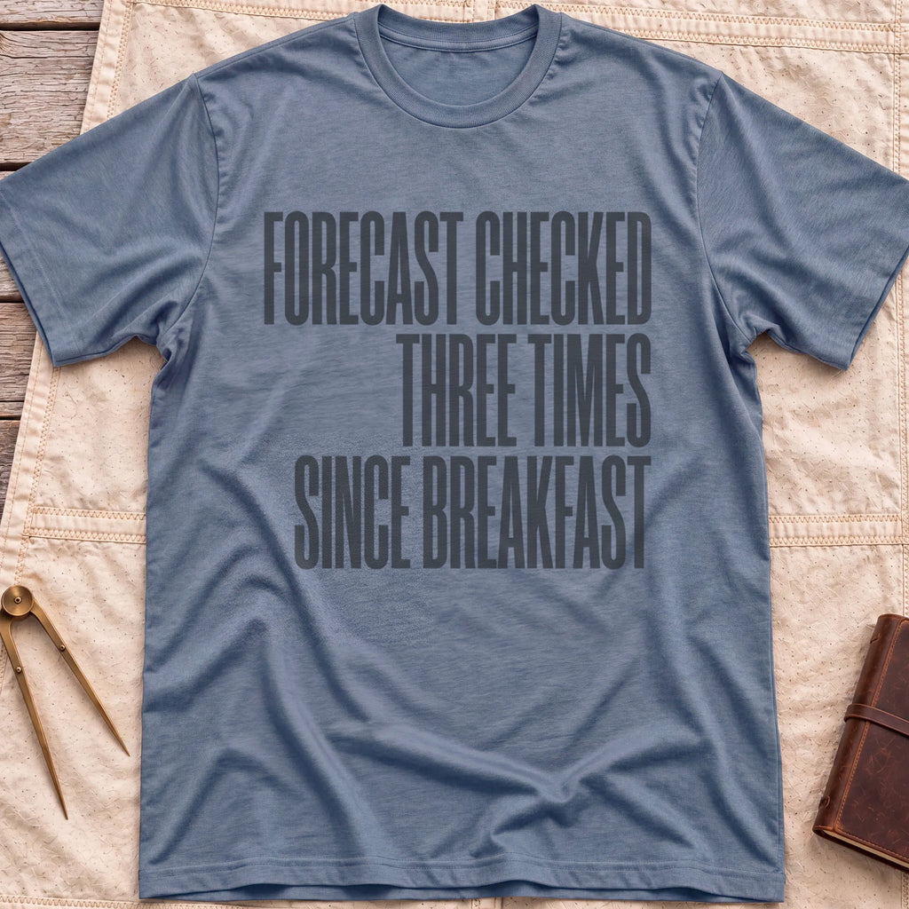 Front view of the heather indigo Forecast Again T-Shirt with the words Forecast Checked Three Times Since Breakfast in tall condensed capitals.