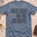 Front view of the heather indigo Forecast Again T-Shirt with the words Forecast Checked Three Times Since Breakfast in tall condensed capitals.
