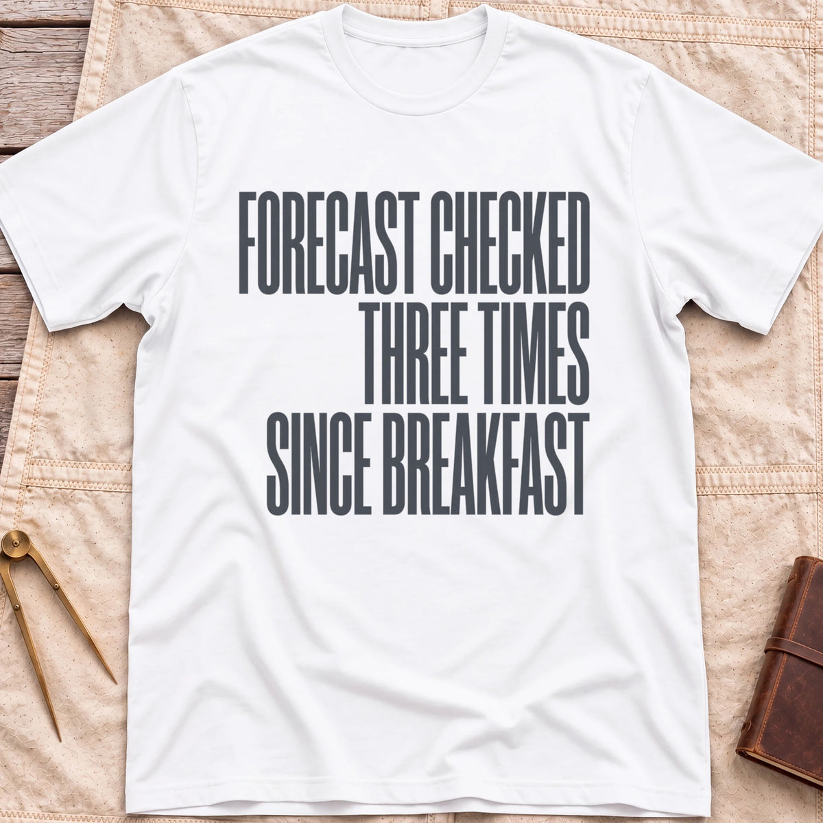 Front view of the white Forecast Again T-Shirt with the words Forecast Checked Three Times Since Breakfast in tall condensed capitals.