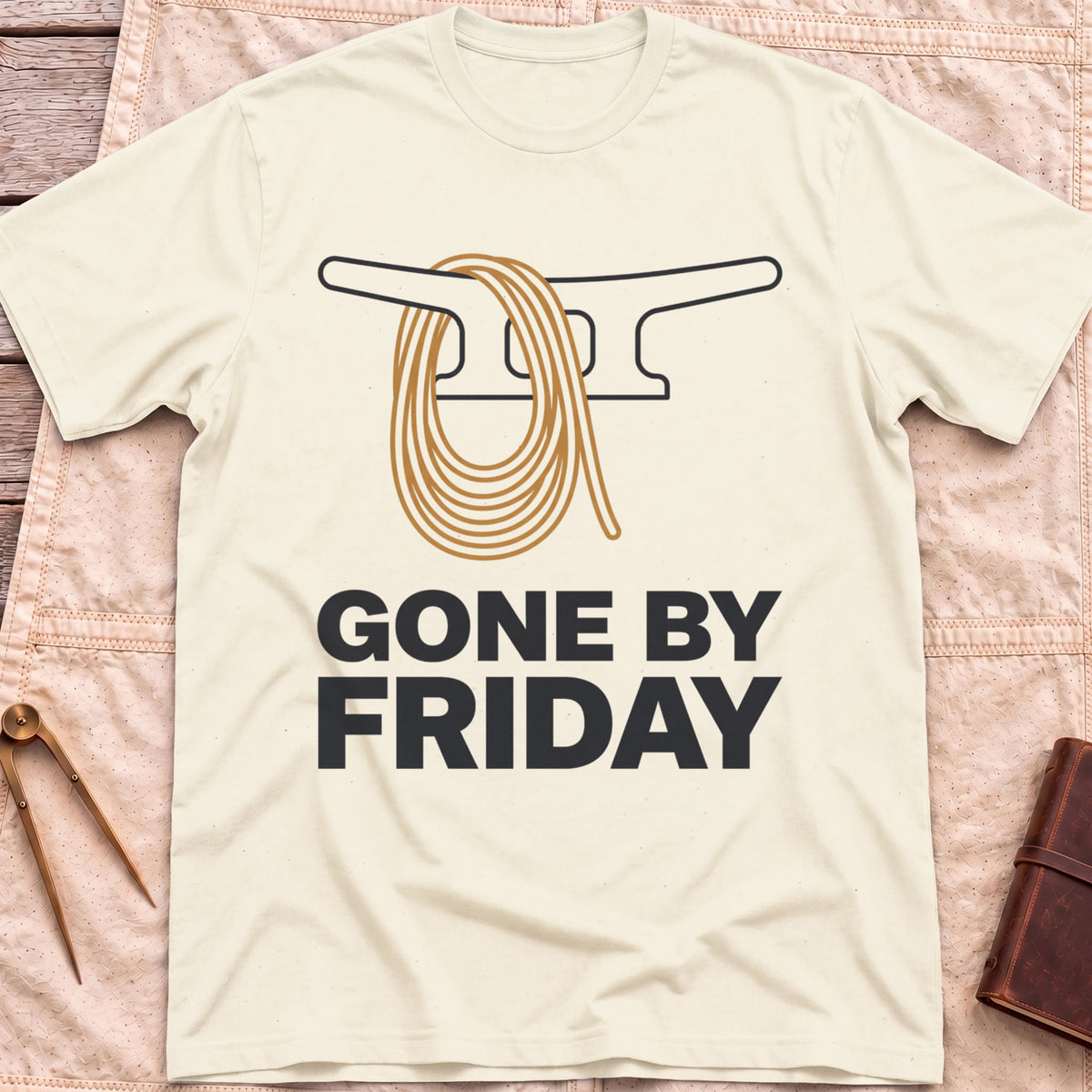 Front view of the natural Gone by Friday T-Shirt with a coiled rope looped over a dock cleat.