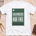 Front view of the white Grandkids Ride Free T-Shirt with a green ticket-shaped graphic reading Grandkids Ride Free.