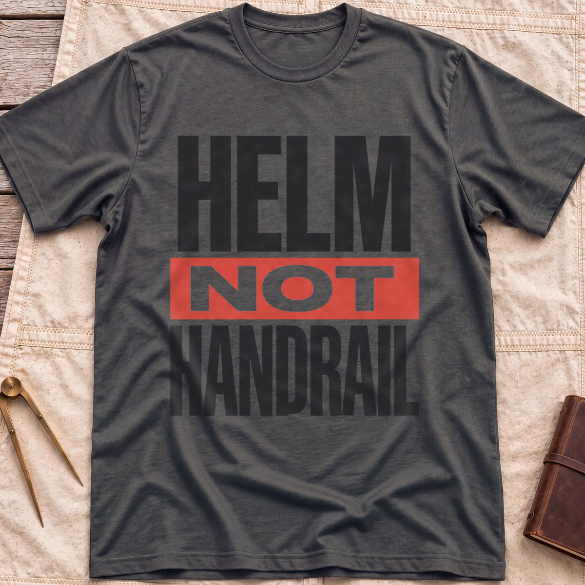 Front view of the dark heather Helm Not Handrail T-Shirt with the words Helm Not Handrail in heavy capitals, Not set on a red bar.