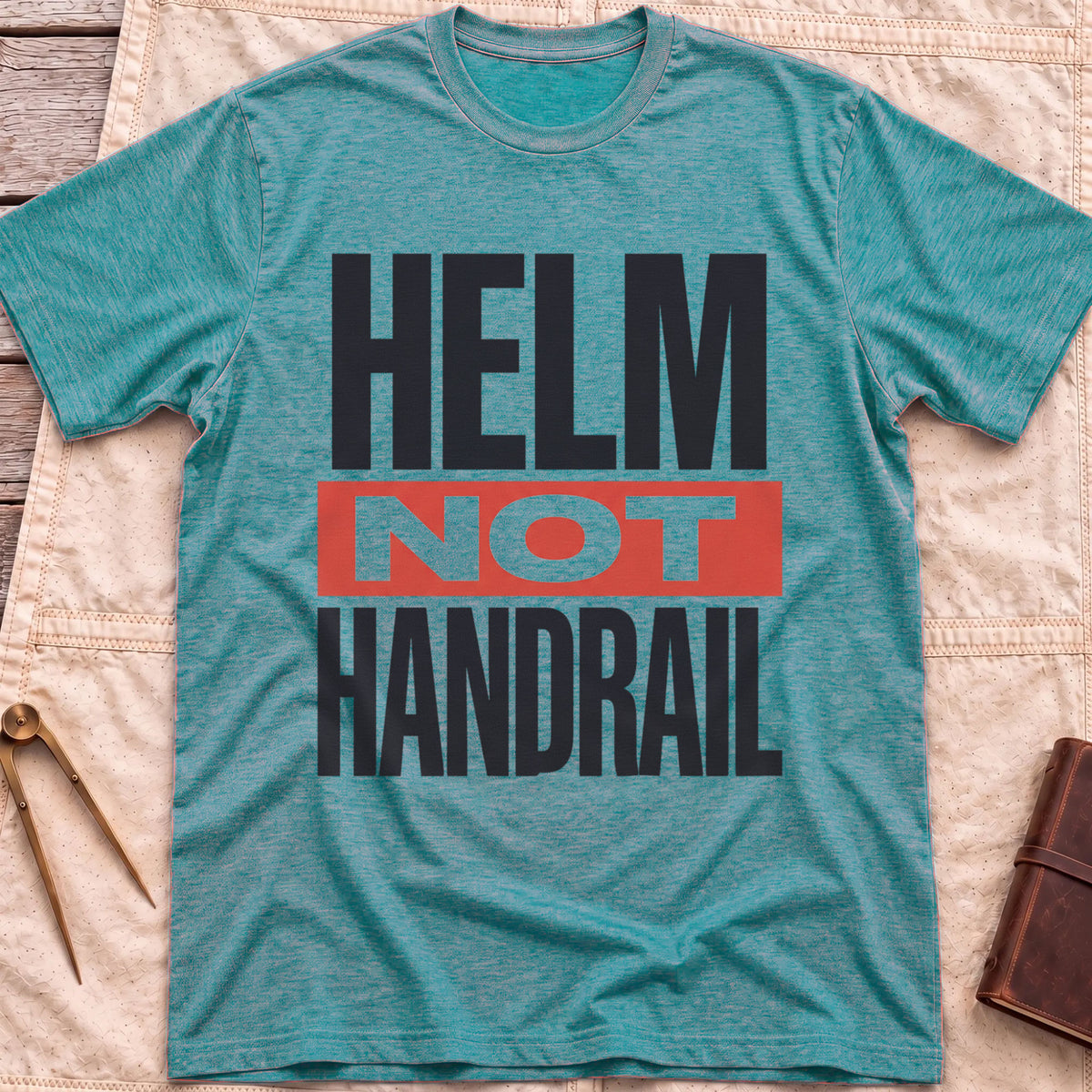 Front view of the heather galapagos blue Helm Not Handrail T-Shirt with the words Helm Not Handrail in heavy capitals, Not set on a red bar.