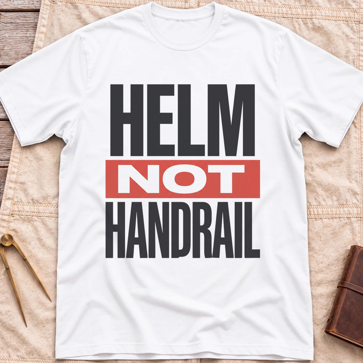 Front view of the white Helm Not Handrail T-Shirt with the words Helm Not Handrail in heavy capitals, Not set on a red bar.