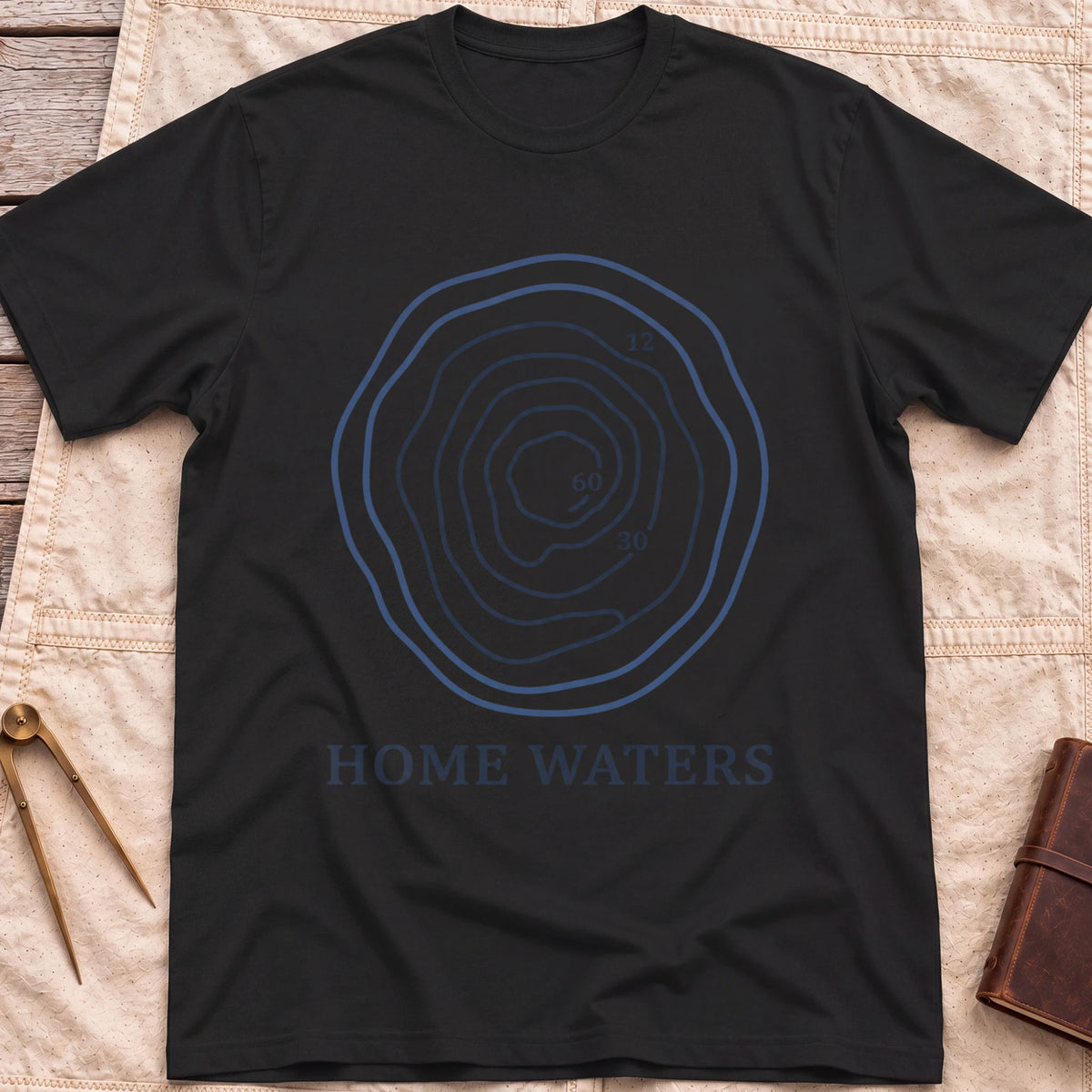 Front view of the black Home Waters T-Shirt with a set of wavy contour lines marked 12, 30 and 60.