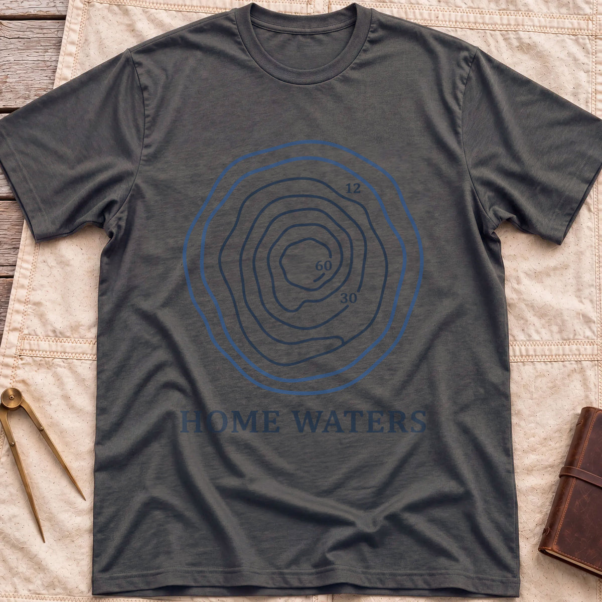 Front view of the dark heather Home Waters T-Shirt with a set of wavy contour lines marked 12, 30 and 60.
