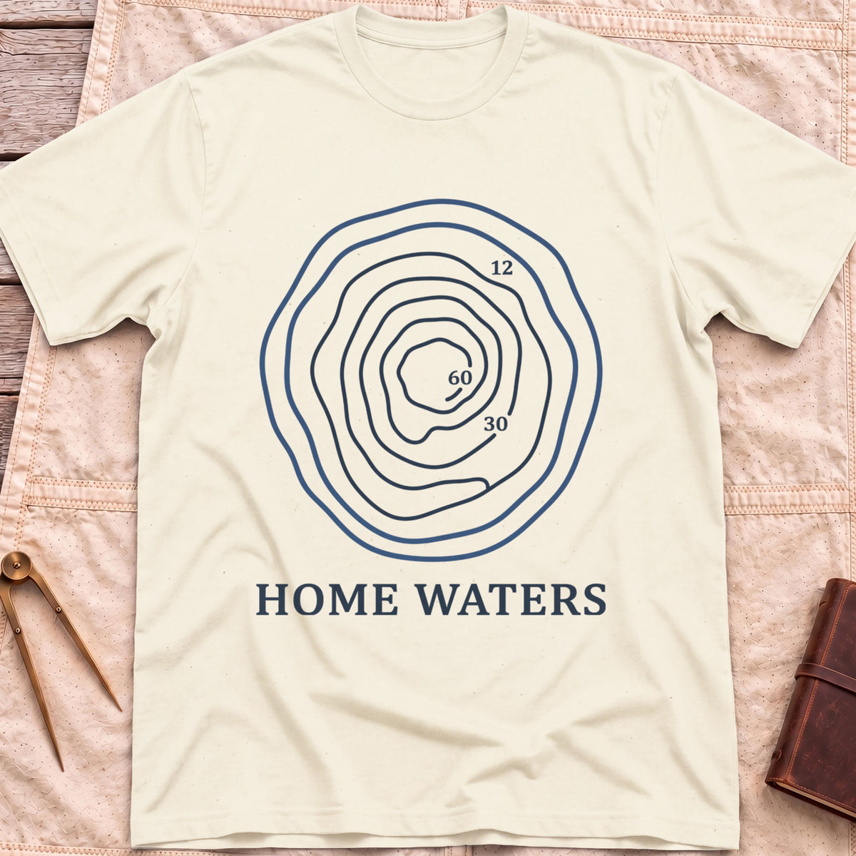 Front view of the natural Home Waters T-Shirt with a set of wavy contour lines marked 12, 30 and 60.