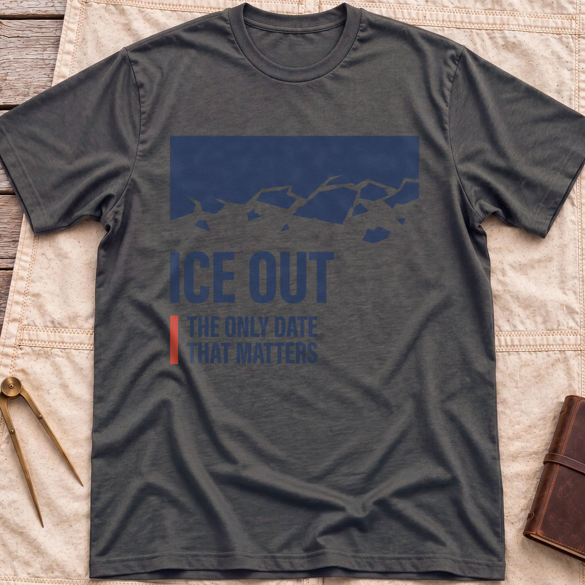 Front view of the dark heather Ice Out T-Shirt with a navy block breaking into ice fragments above the words The Only Date That Matters.