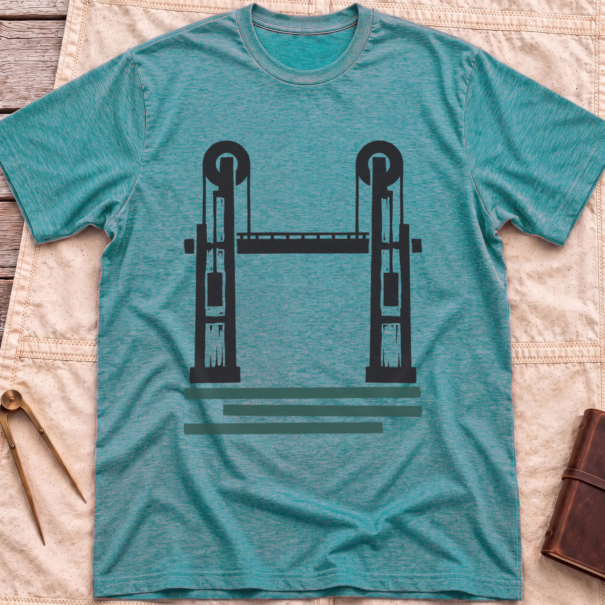 Front view of the heather galapagos blue Lift Bridge T-Shirt with a silhouette of a lift bridge, its two towers topped with wheels.