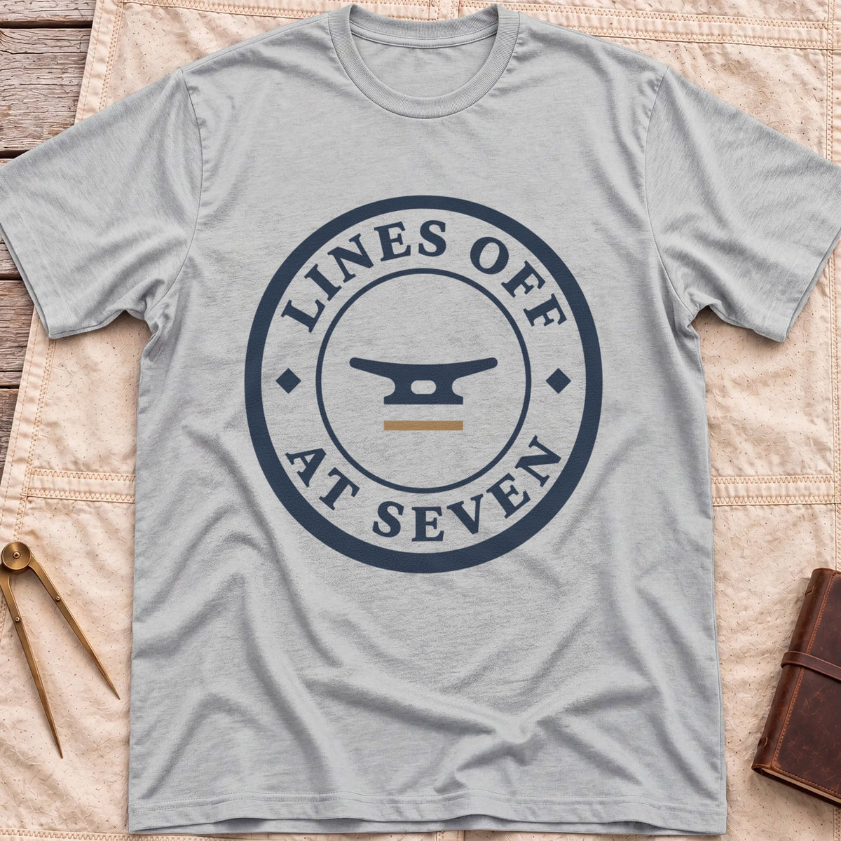 Front view of the sport grey Lines Off at Seven T-Shirt with a round badge showing a dock cleat, ringed by the words Lines Off at Seven.