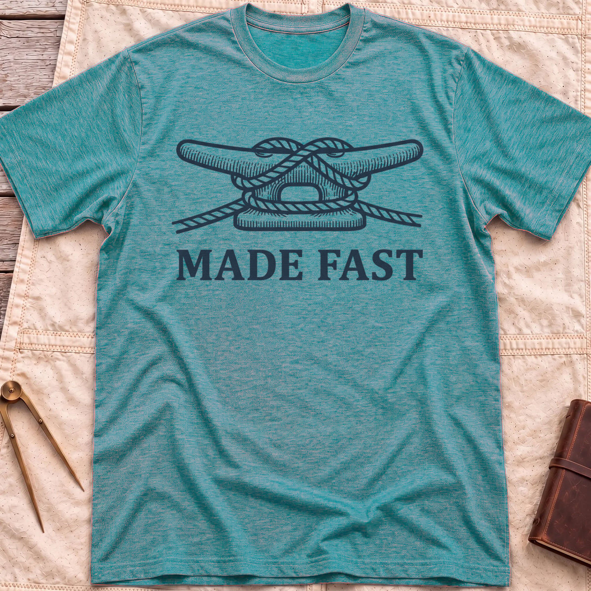 Front view of the heather galapagos blue Made Fast T-Shirt with a rope tied off around a dock cleat.