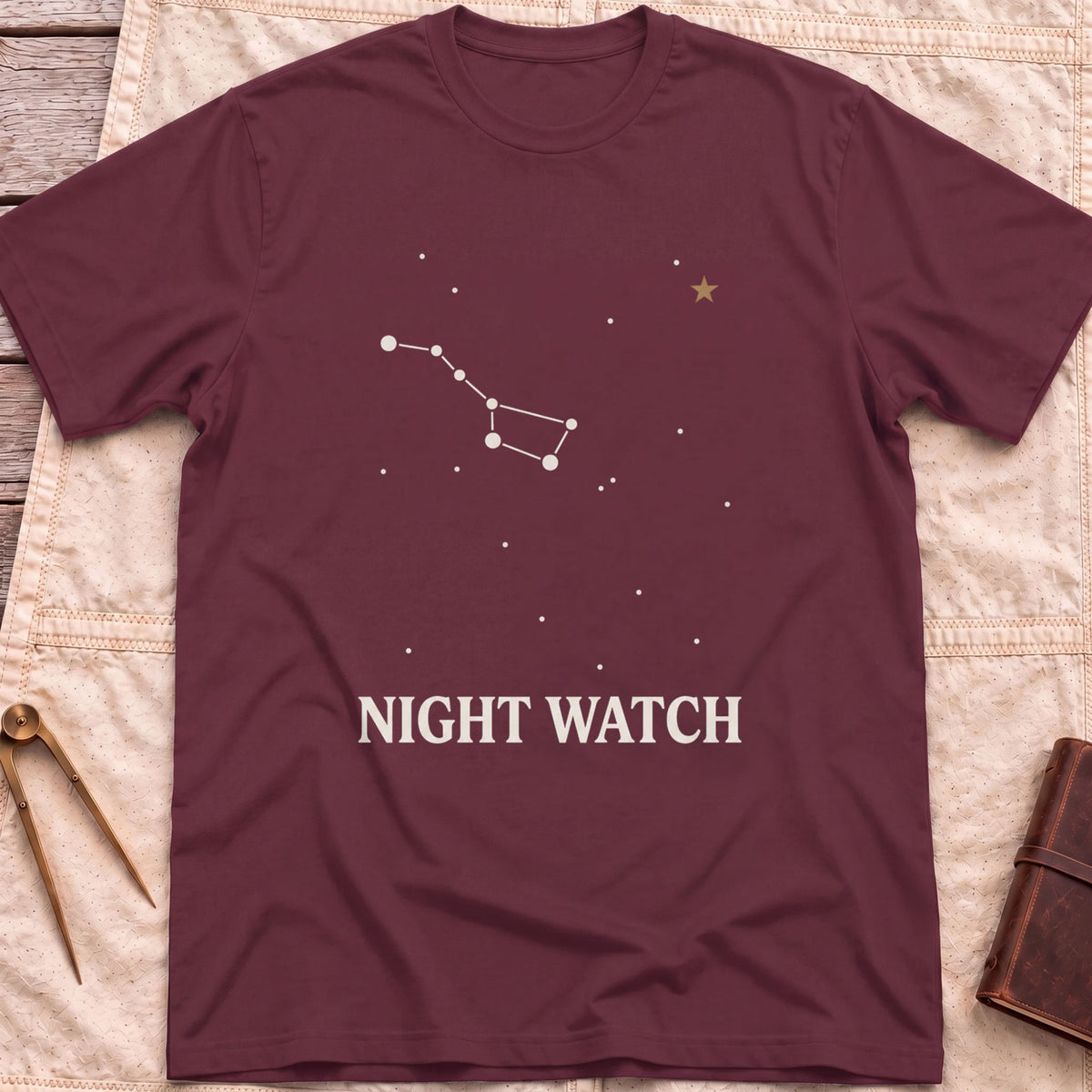 Front view of the maroon Night Watch T-Shirt with a constellation of joined stars, a small gold star and the words Night Watch.