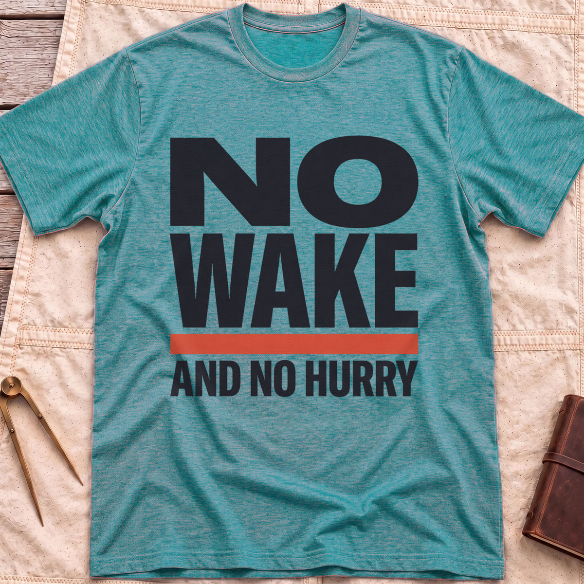 Front view of the heather galapagos blue No Wake T-Shirt with the words No Wake in large bold letters over a red bar and the line And No Hurry.