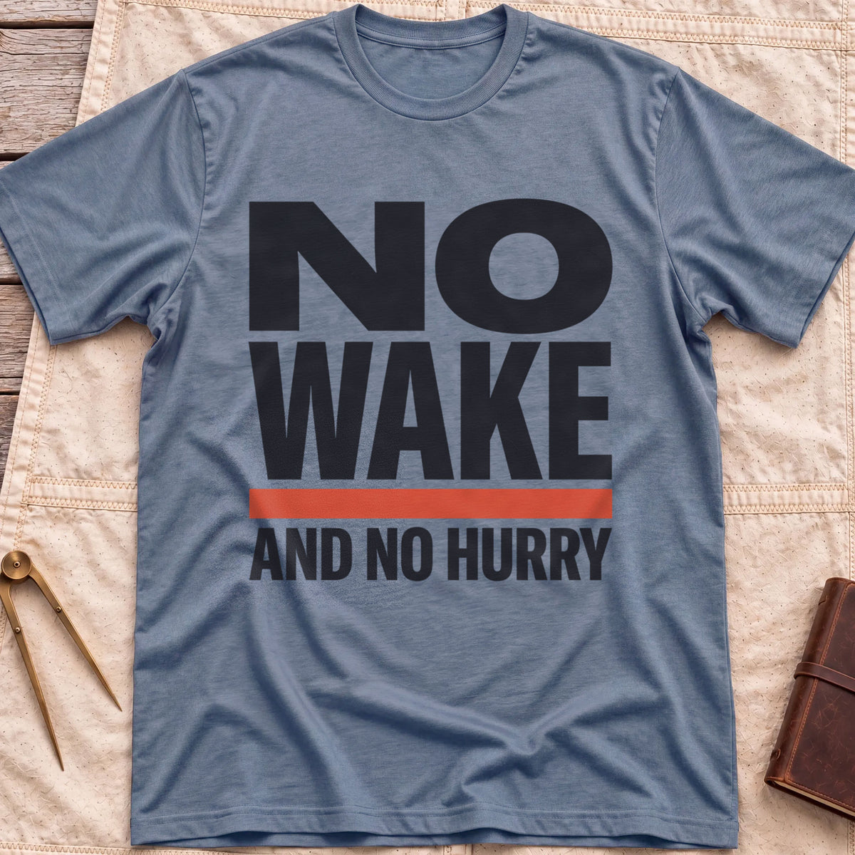 Front view of the heather indigo No Wake T-Shirt with the words No Wake in large bold letters over a red bar and the line And No Hurry.