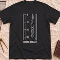 Front view of the black On One Breath T-Shirt with a diver descending headfirst beside a depth scale from 0 to 30, above the words On One Breath.