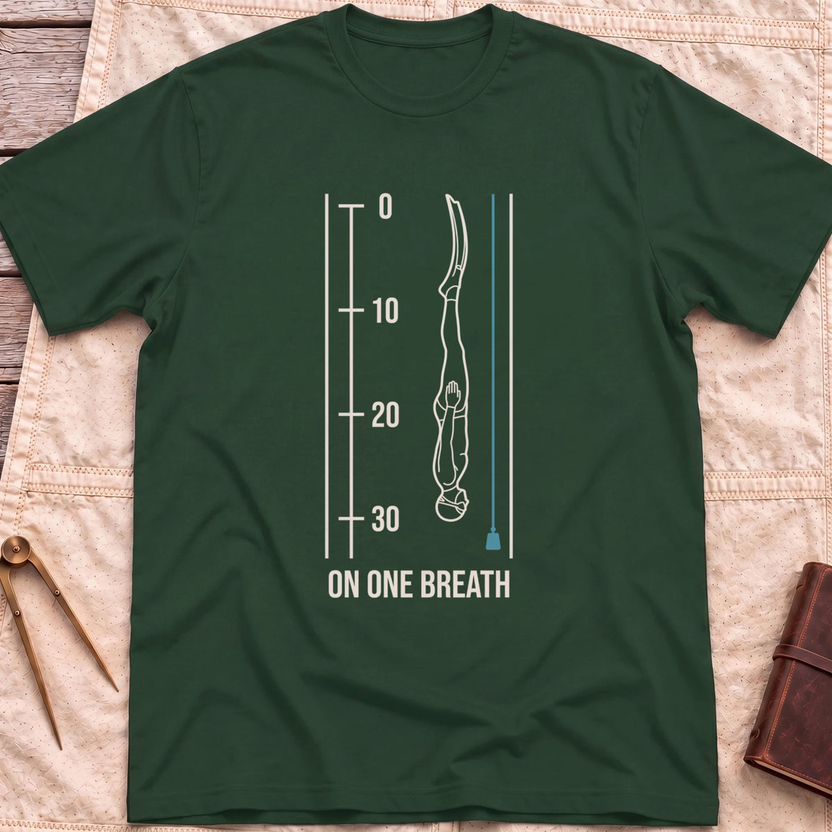 Front view of the forest green On One Breath T-Shirt with a diver descending headfirst beside a depth scale from 0 to 30, above the words On One Breath.