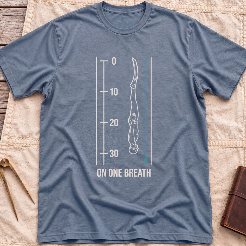 Front view of the heather indigo On One Breath T-Shirt with a diver descending headfirst beside a depth scale from 0 to 30, above the words On One Breath.