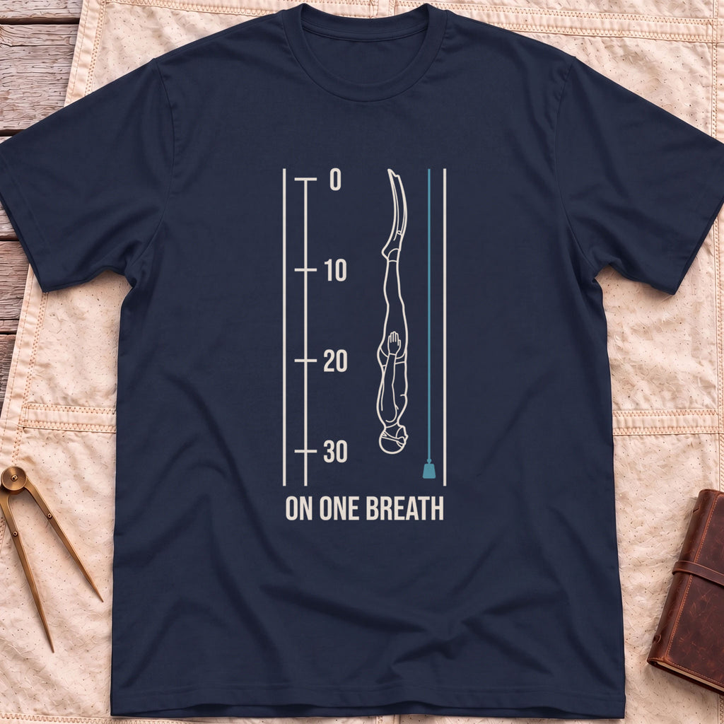 Front view of the navy On One Breath T-Shirt with a diver descending headfirst beside a depth scale from 0 to 30, above the words On One Breath.