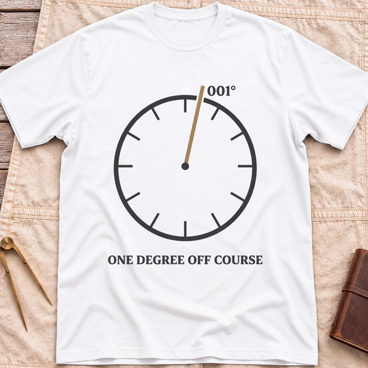 Front view of the white One Degree Off Course T-Shirt with a round dial and a tan needle pointing to 001°.