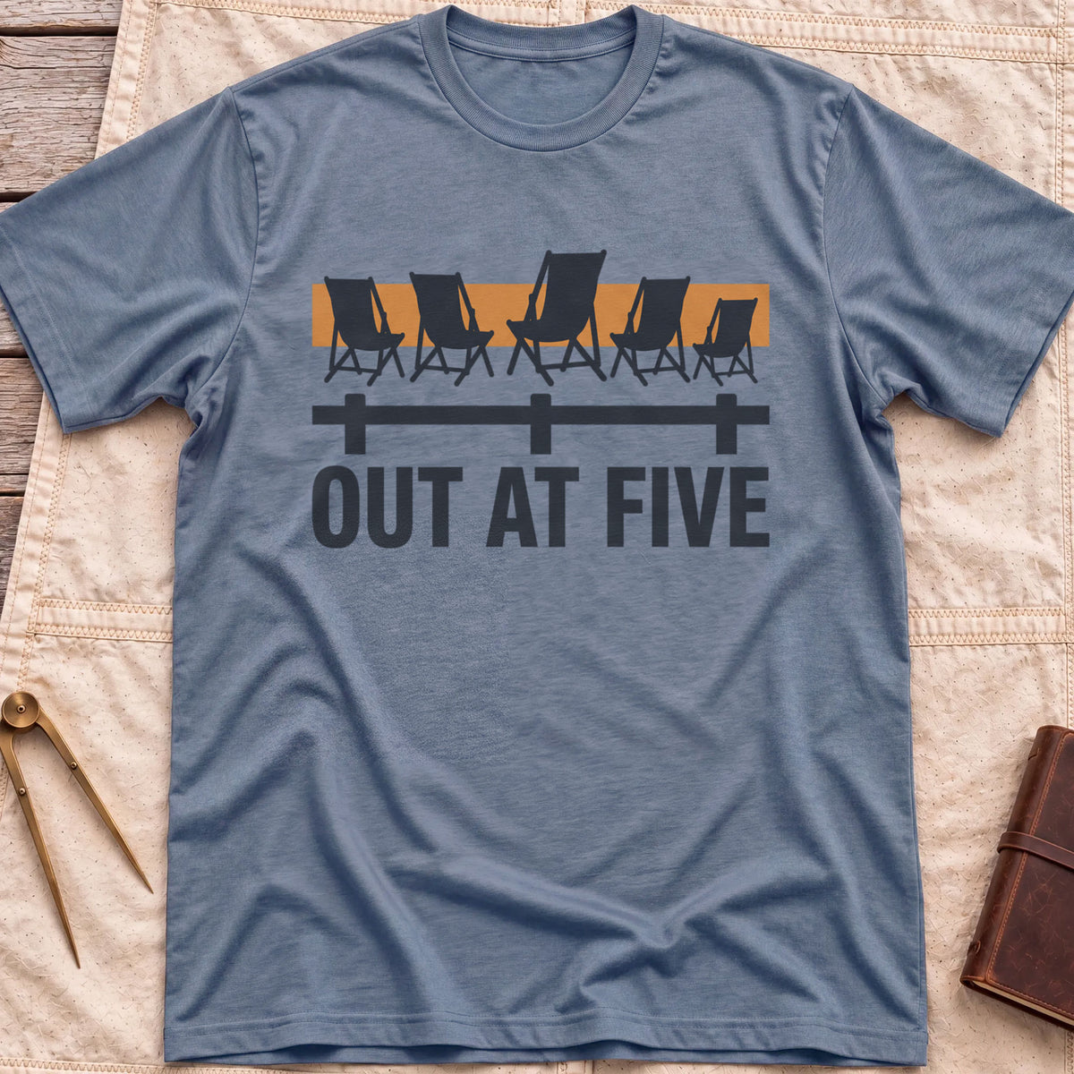 Front view of the heather indigo Out at Five T-Shirt with a row of folding chairs along a dock rail against an orange band, above the words Out at Five.