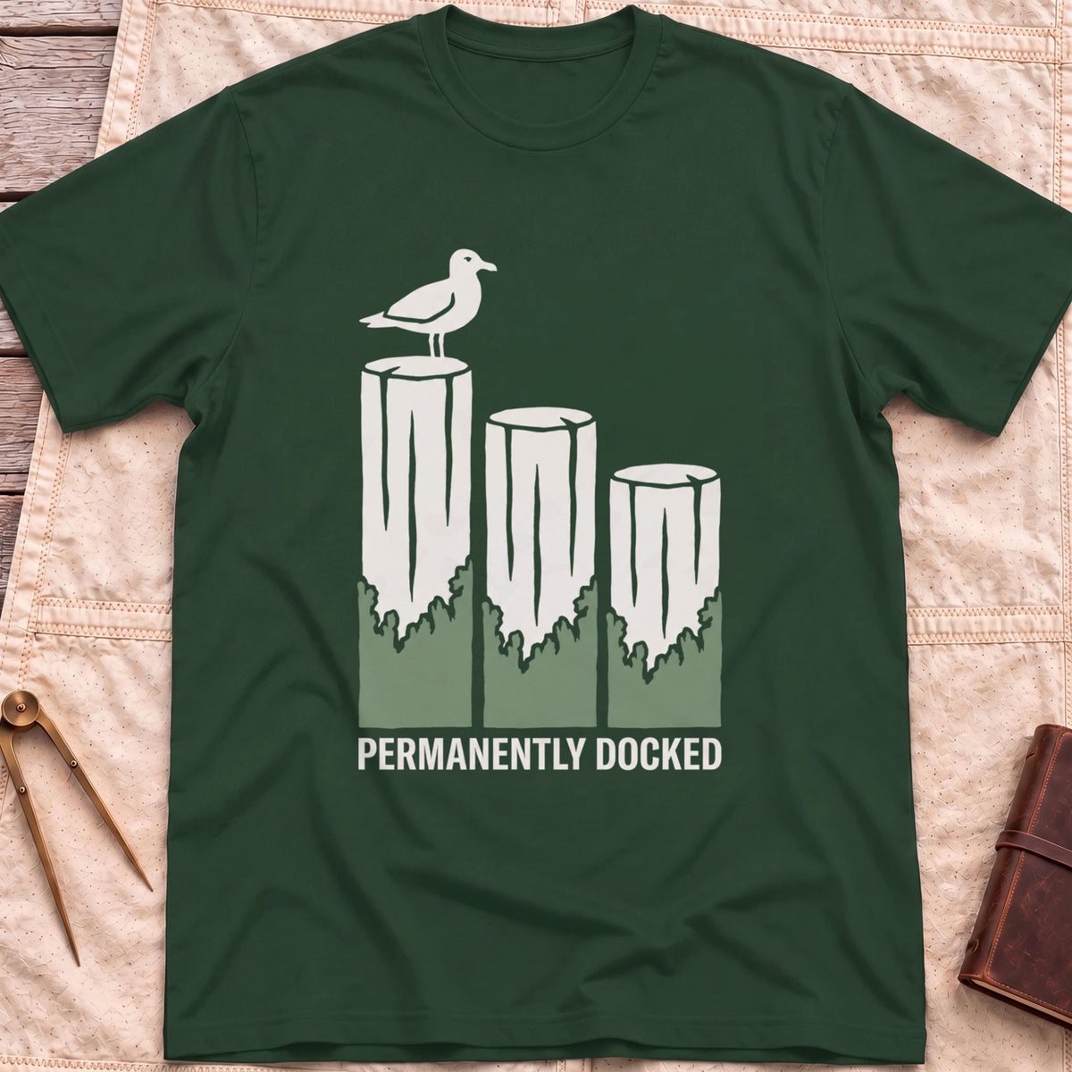 Front view of the forest green Permanently Docked T-Shirt with a seagull perched on three wooden pilings.