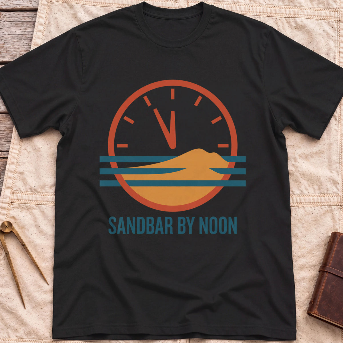 Front view of the black Sandbar by Noon T-Shirt with a clock face set just before twelve above a sandbar and water lines.