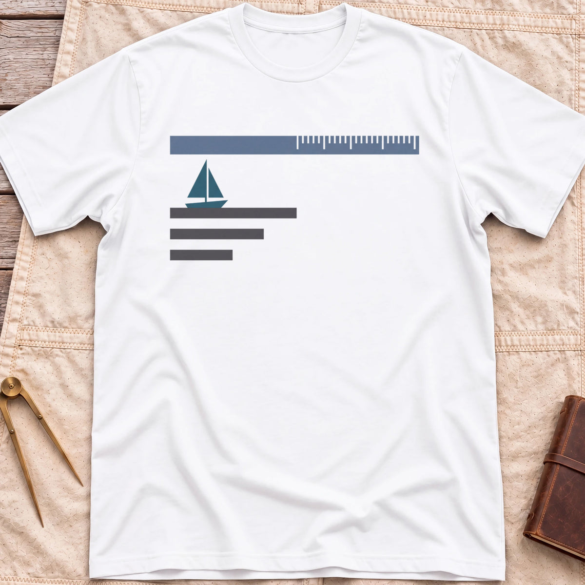 Front view of the white Sea Room T-Shirt with a small sailboat beneath a long scale bar, above three stacked lines.