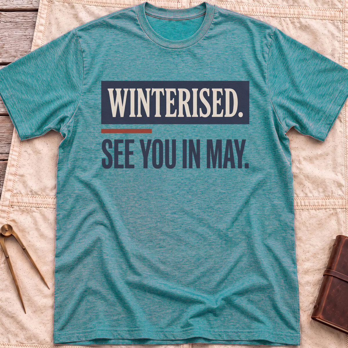 Front view of the heather galapagos blue See You in May T-Shirt with the words Winterised. See You in May. in bold condensed type.