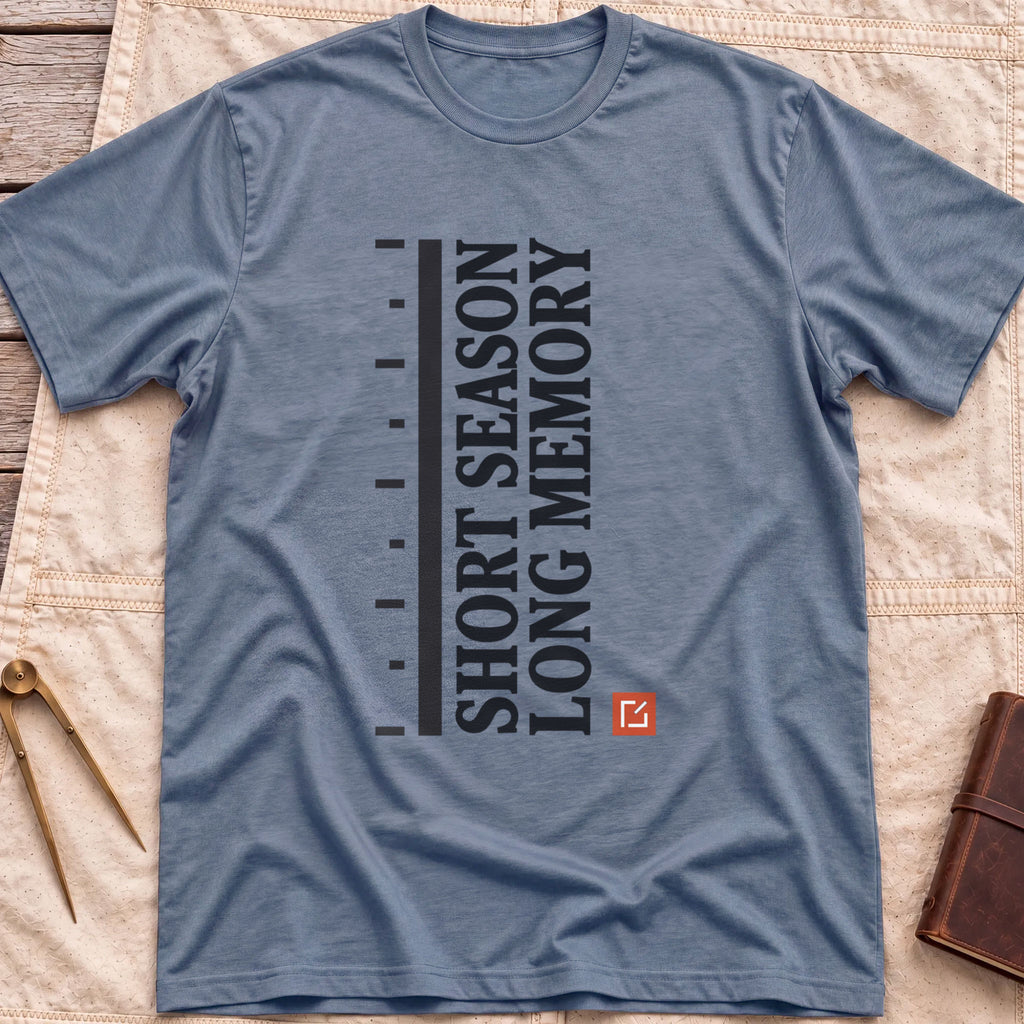 Front view of the heather indigo Short Season Long Memory T-Shirt with the words Short Season Long Memory running vertically beside a tick-marked scale and a small red square.