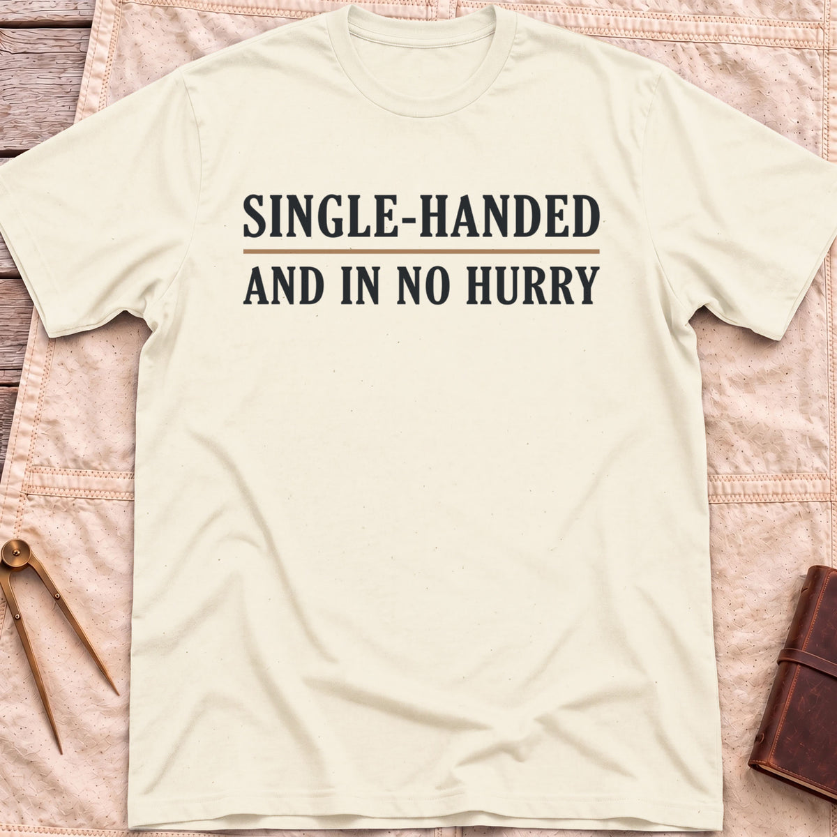 Front view of the natural Single Handed T-Shirt with the words Single-Handed and In No Hurry in serif capitals.