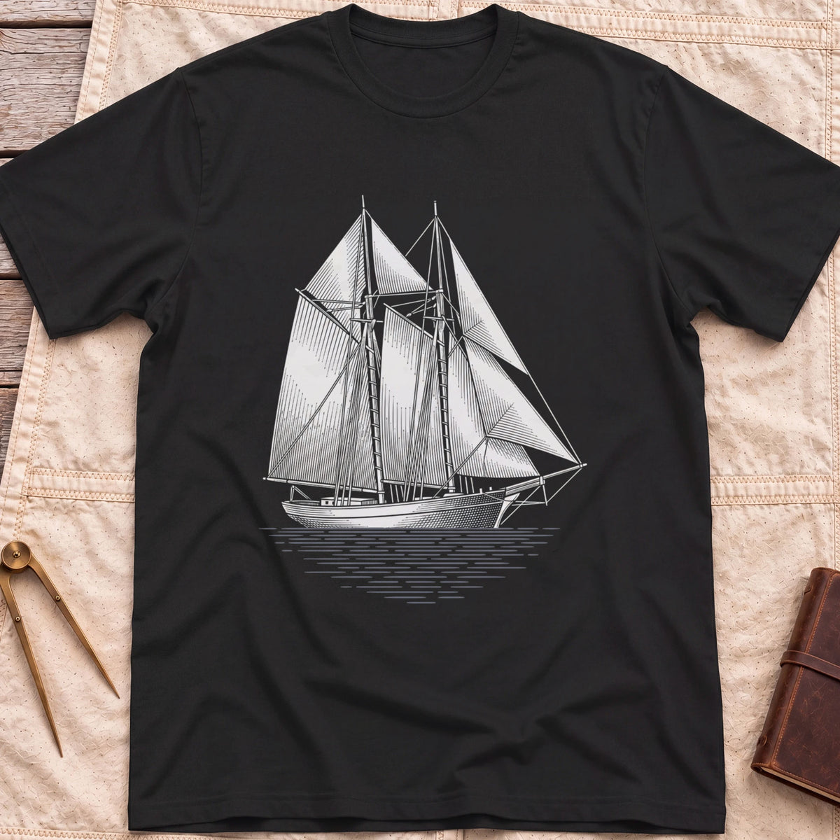 Front view of the black Snug Harbour T-Shirt with a detailed white illustration of a two-masted sailing ship on the water.