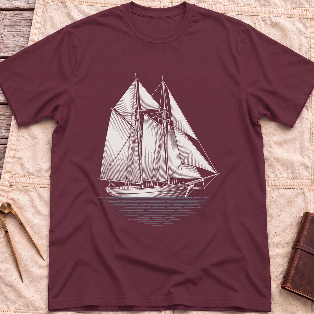 Front view of the maroon Snug Harbour T-Shirt with a detailed white illustration of a two-masted sailing ship on the water.