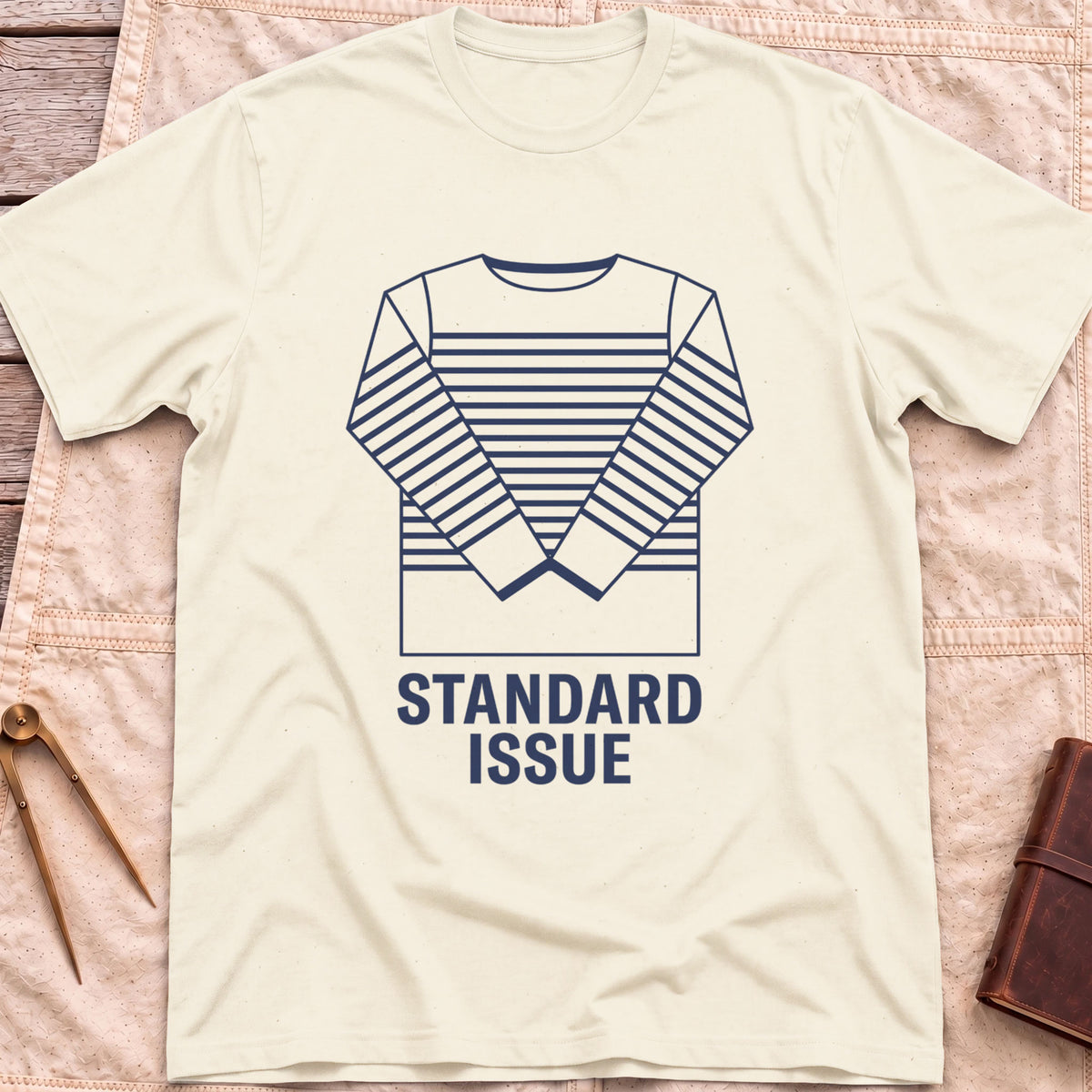 Front view of the natural Standard Issue T-Shirt with a line drawing of a striped long-sleeve top above the words Standard Issue.