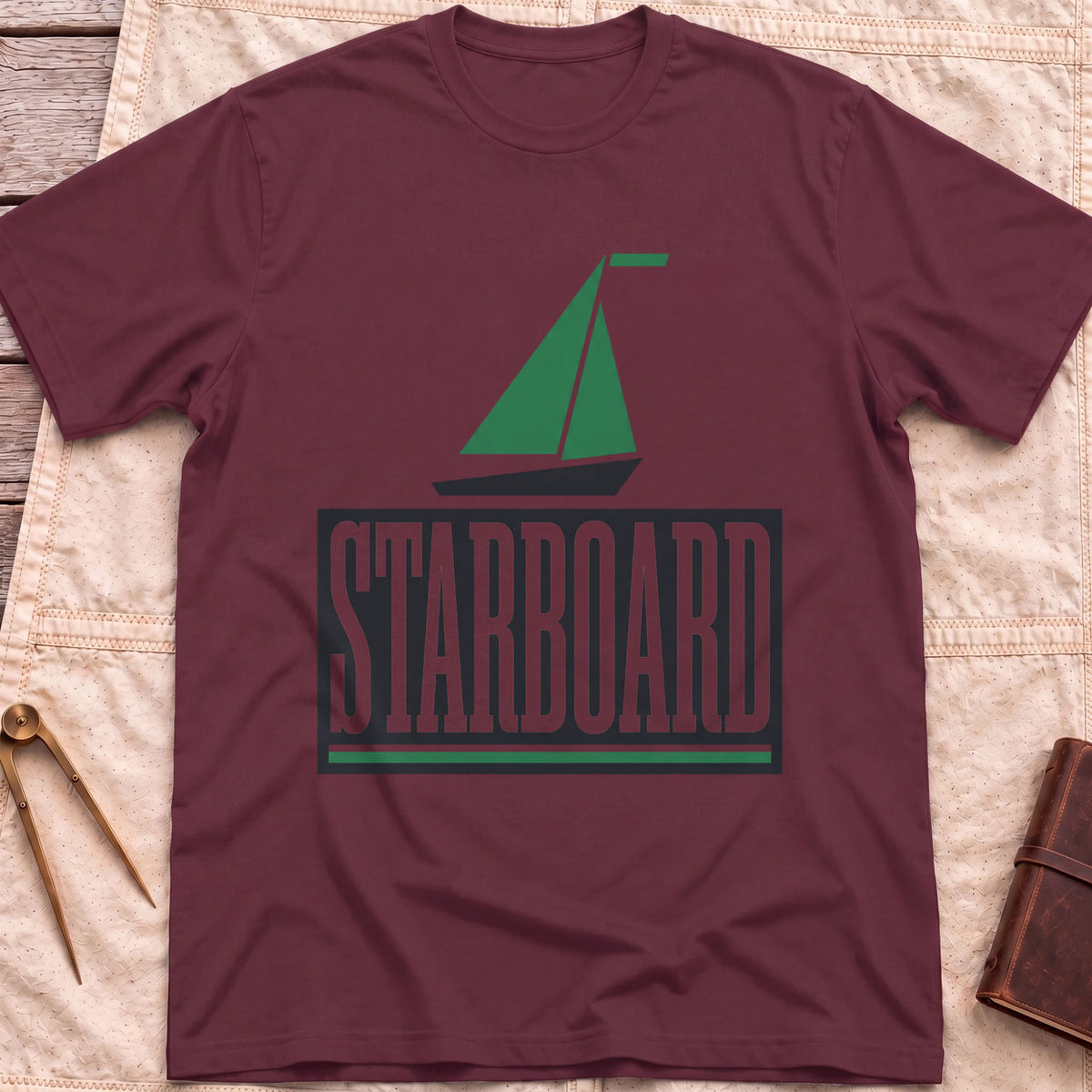 Front view of the maroon Starboard T-Shirt with a green sailboat above the word Starboard in a dark panel.