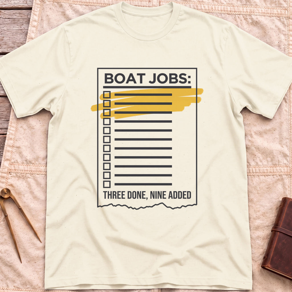 Front view of the natural Still on the List T-Shirt with a Boat Jobs checklist, its top items highlighted in yellow, above the words Three Done, Nine Added.