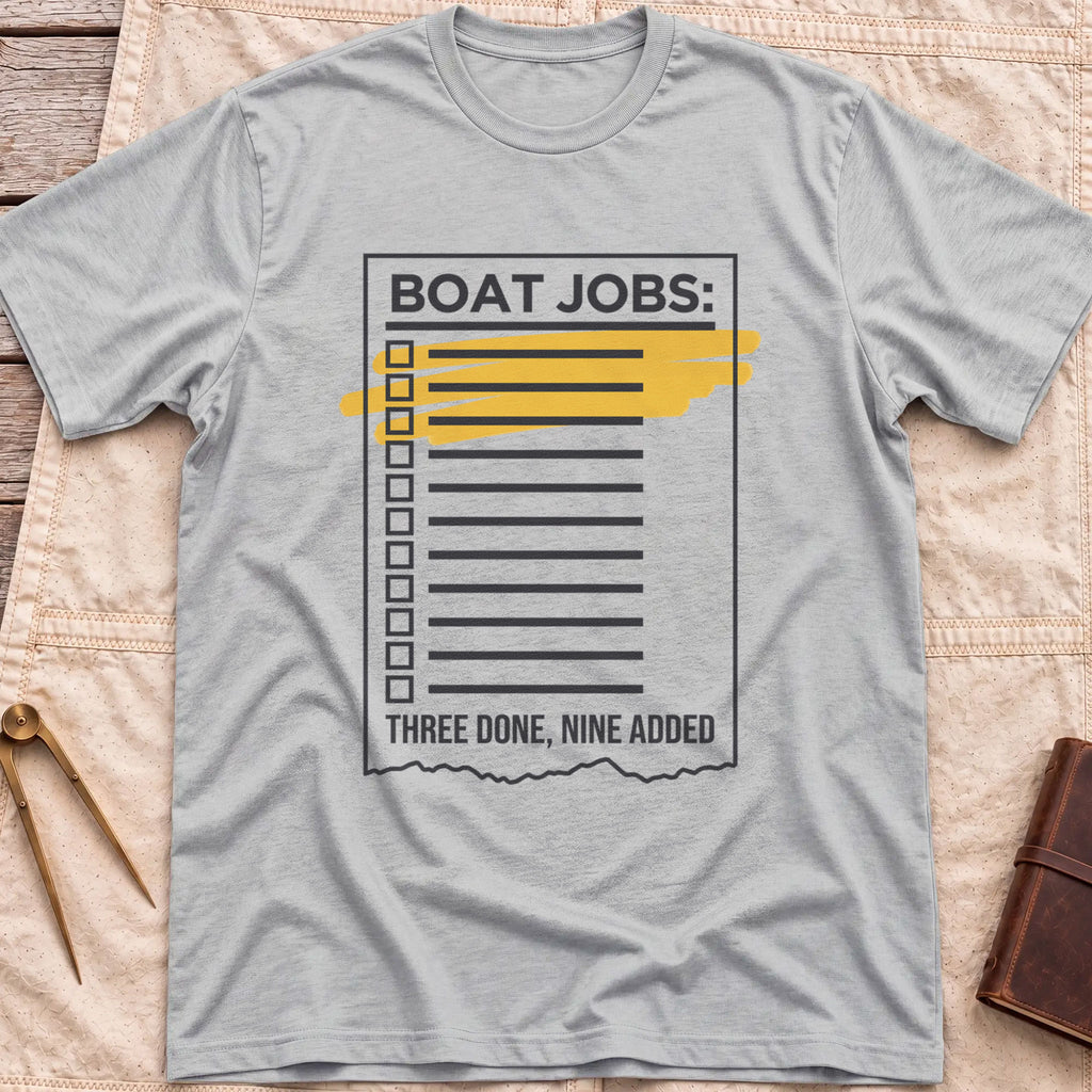Front view of the sport grey Still on the List T-Shirt with a Boat Jobs checklist, its top items highlighted in yellow, above the words Three Done, Nine Added.