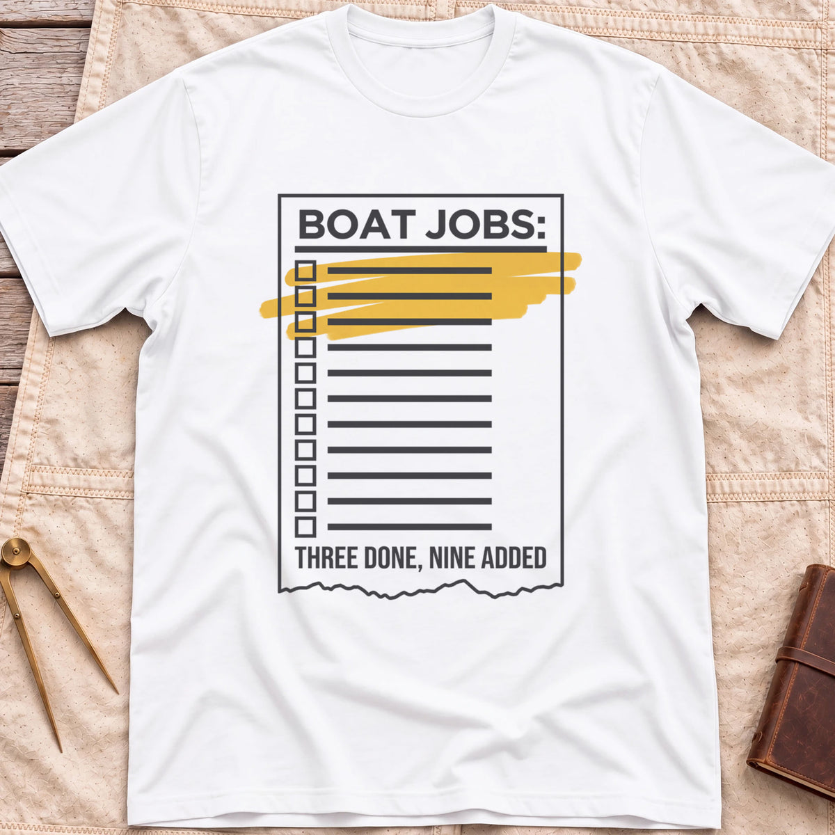 Front view of the white Still on the List T-Shirt with a Boat Jobs checklist, its top items highlighted in yellow, above the words Three Done, Nine Added.
