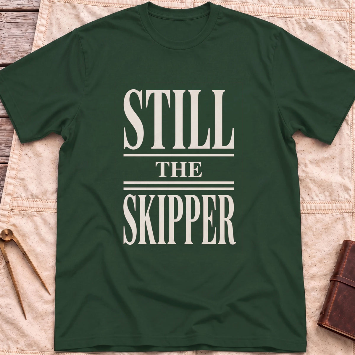 Front view of the forest green Still the Skipper T-Shirt with the words Still the Skipper in cream serif capitals.