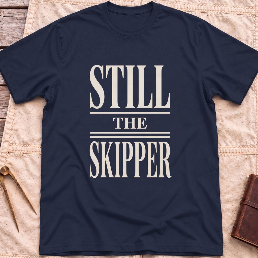 Front view of the navy Still the Skipper T-Shirt with the words Still the Skipper in cream serif capitals.
